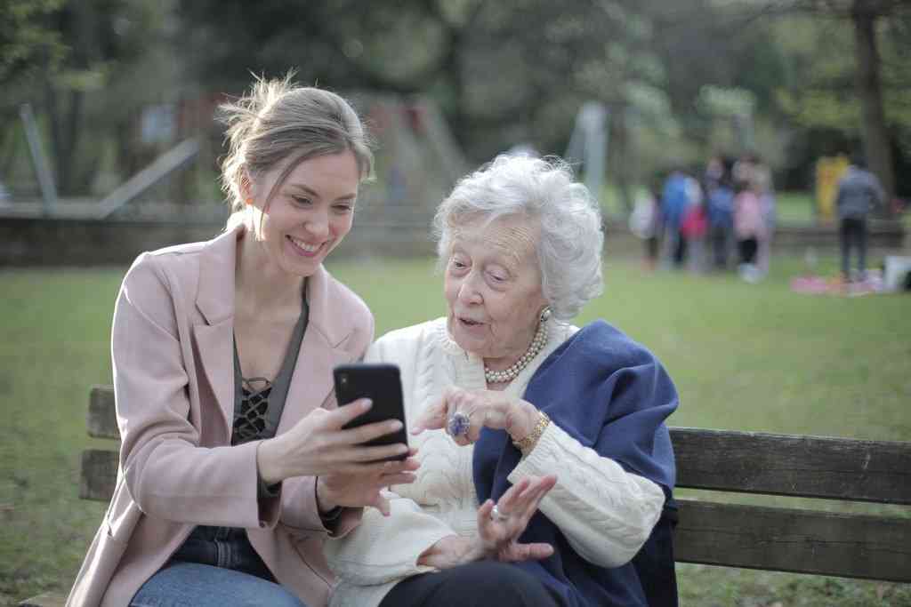 Девушка показывает бабуле что-то на смартфоне