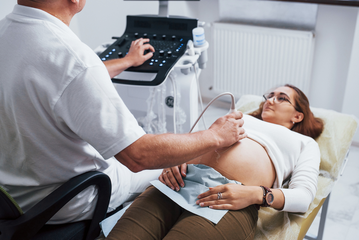 Сильно беременная женщина в больнице на ультразвуке