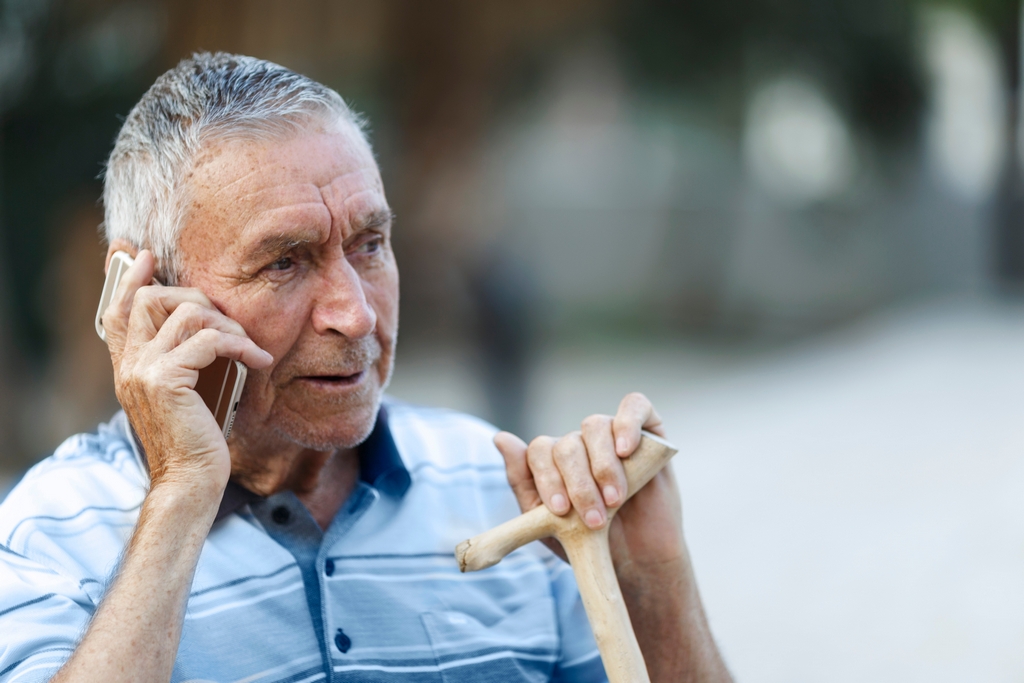 Мужчина пенсионер разговаривает по телефону