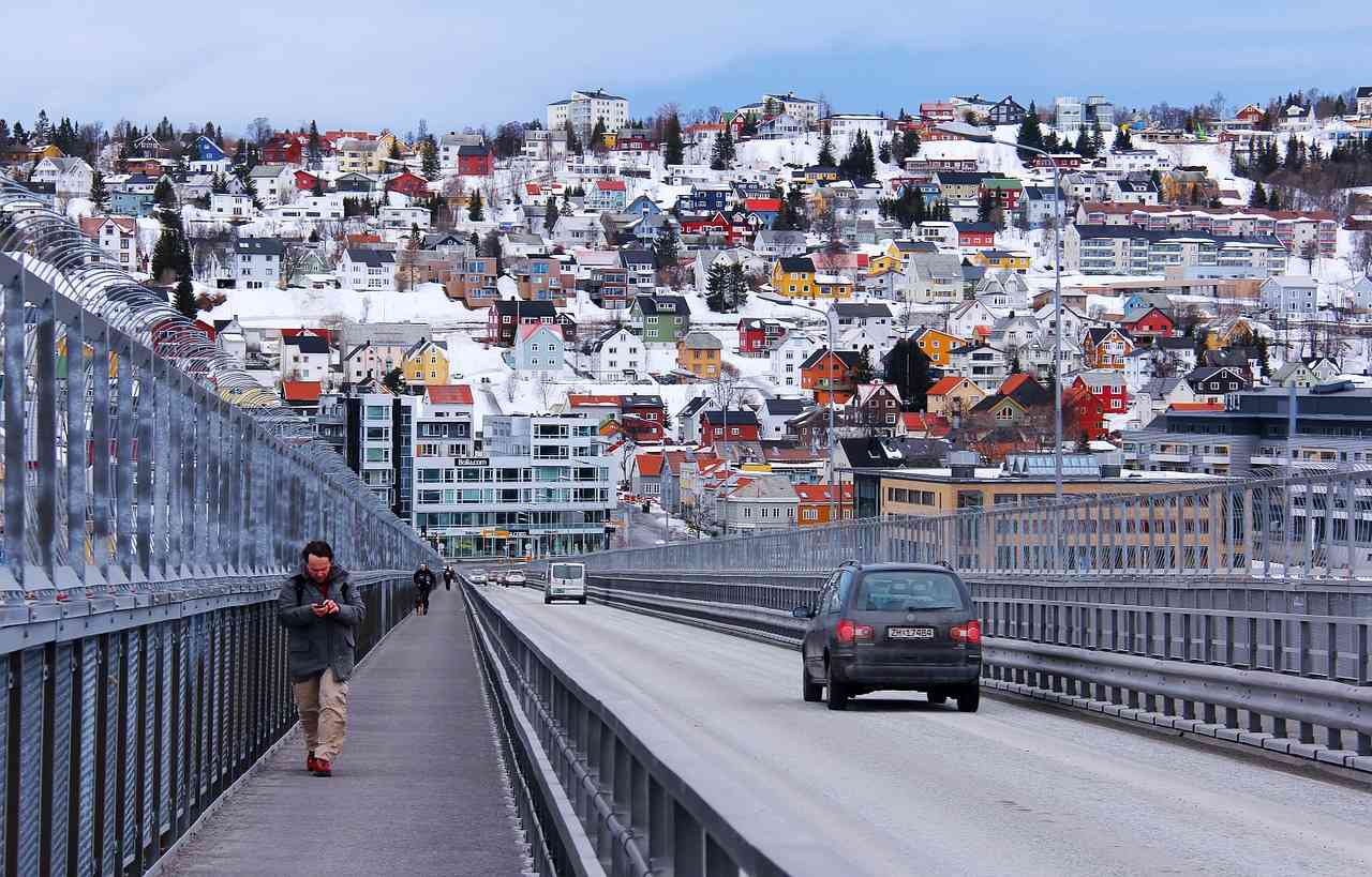 Мост в Тромсё, Норвегия, по нему идет человек и едет машина