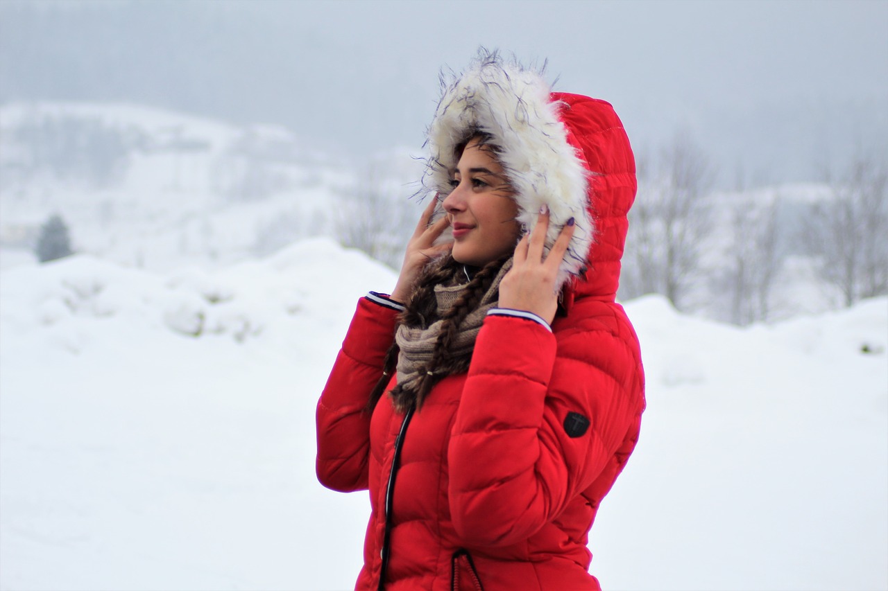 Женщина в красном пуховике зимой